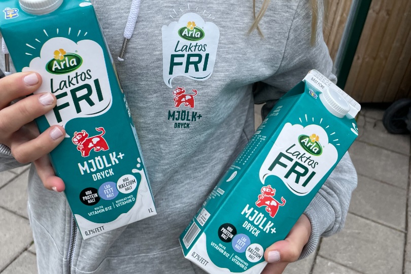 Two cartons of Arla lactose-free milk held up