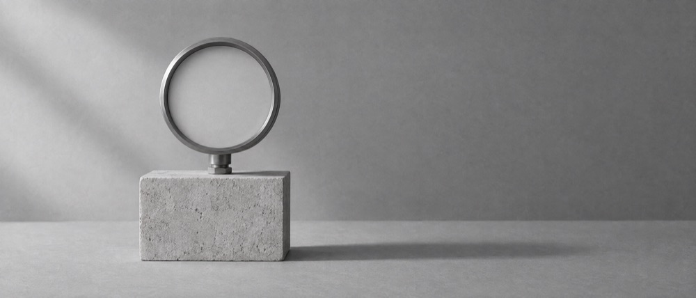 Photograph, greyscale: a round measuring dial on a stone block, its face blank and its needle missing